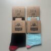 Two pairs of socks wrapped on a plain background, black / red and teal pink