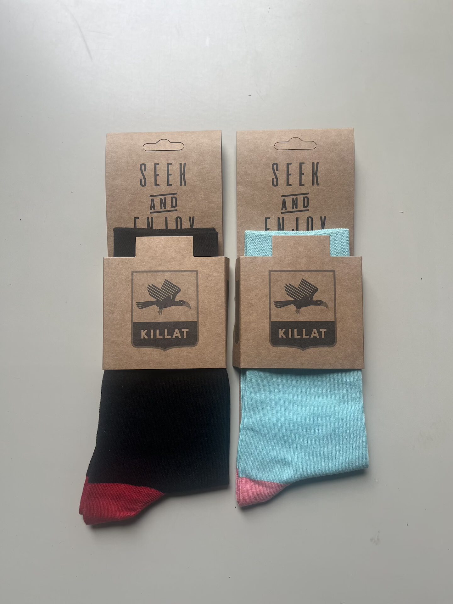 Two pairs of socks wrapped on a plain background, black / red and teal pink