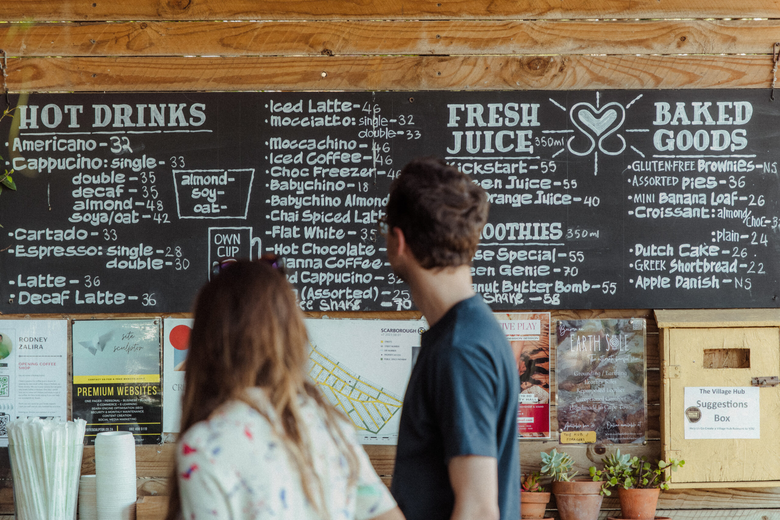 Guy and girl looking at handwritten sign with all options for food and beverages