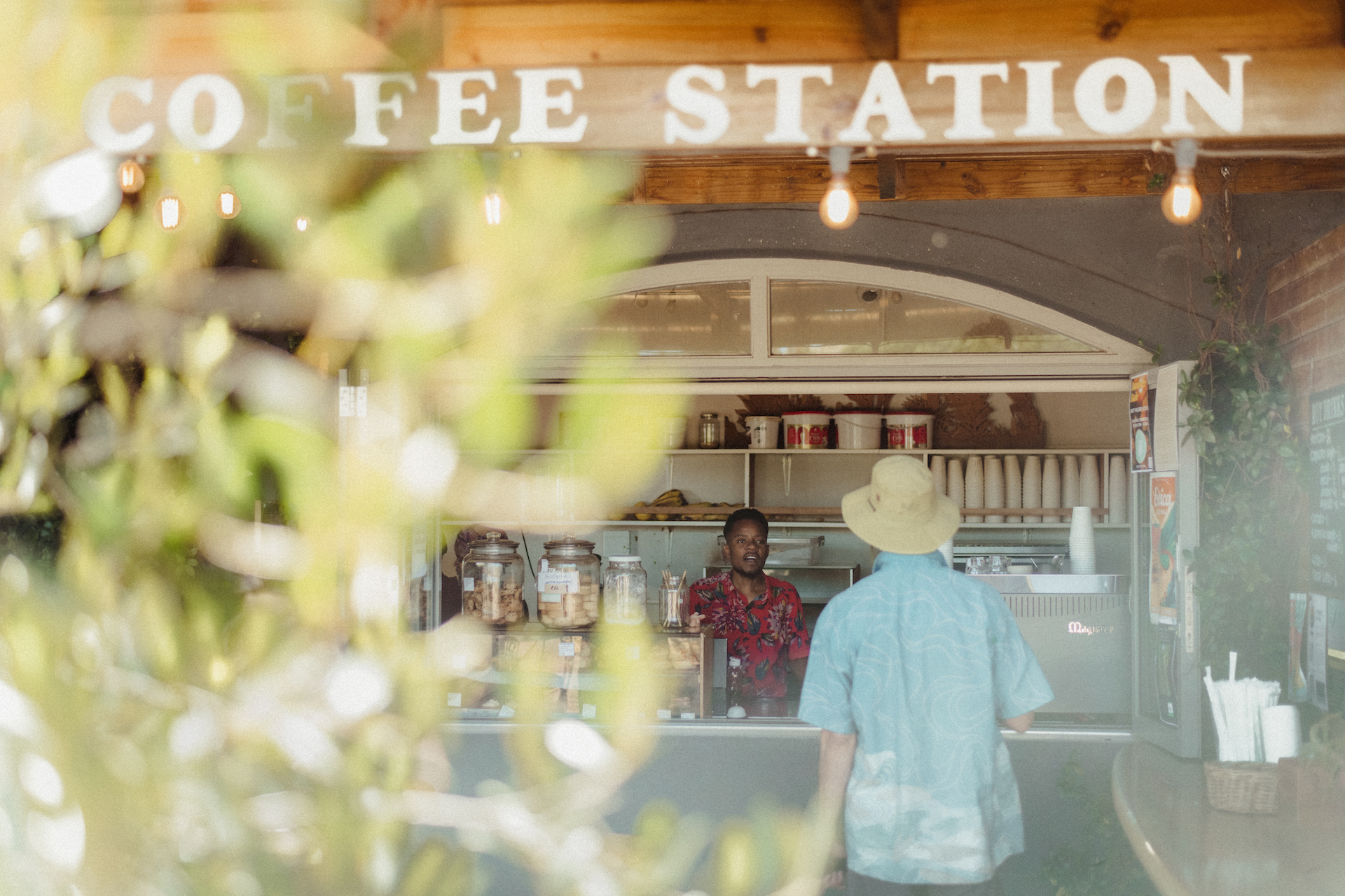 Outside coffee station with guy with a hat about to order some.