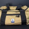 The Weekender sand duffle bag on a black background.