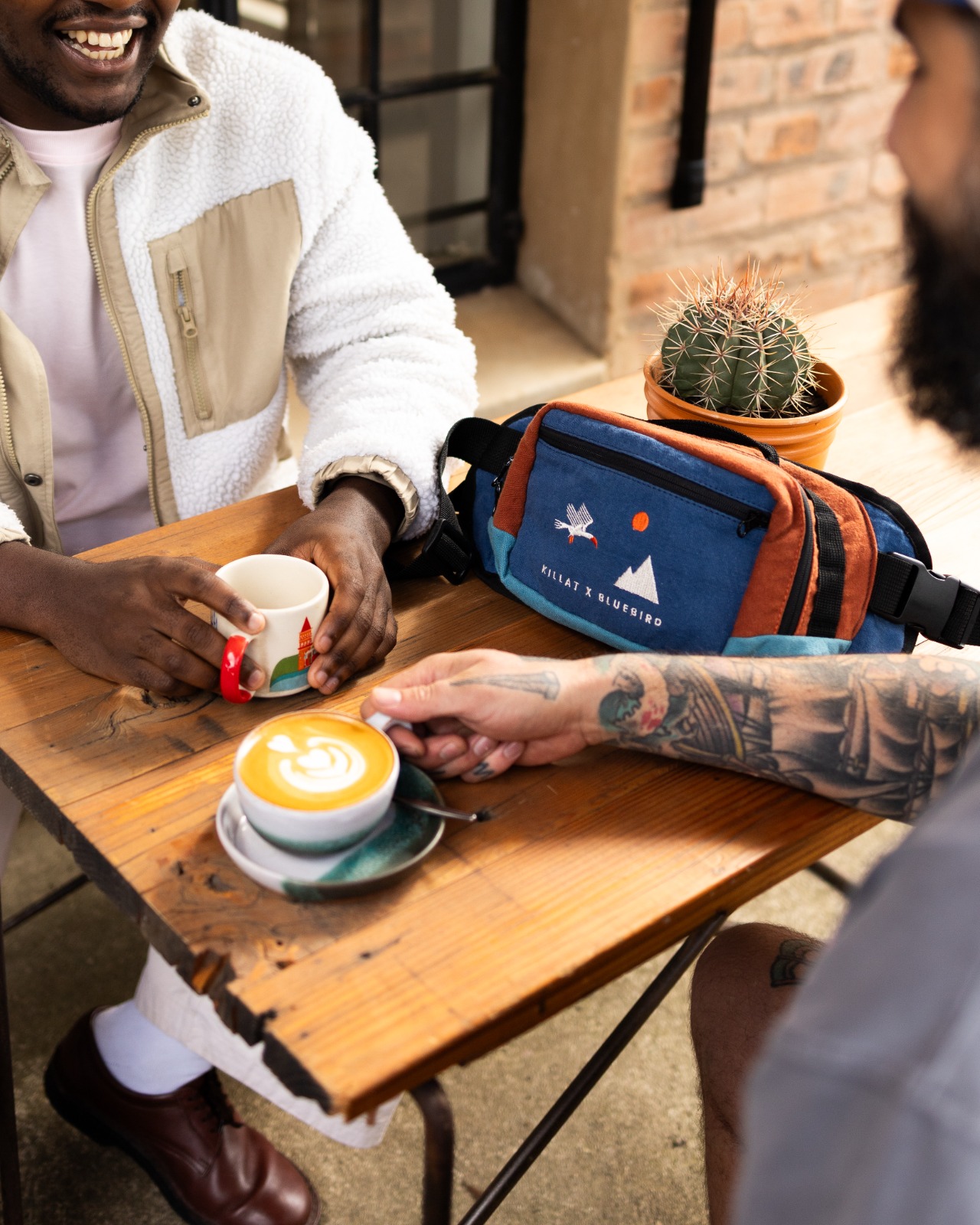 Bluebird Killat coffee Two gents having coffee with a bluebird x killat wax moon bag on the table