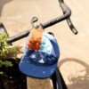 Bluebird x Killat cap A Bluebird Roastery x Killat cap on a road bike